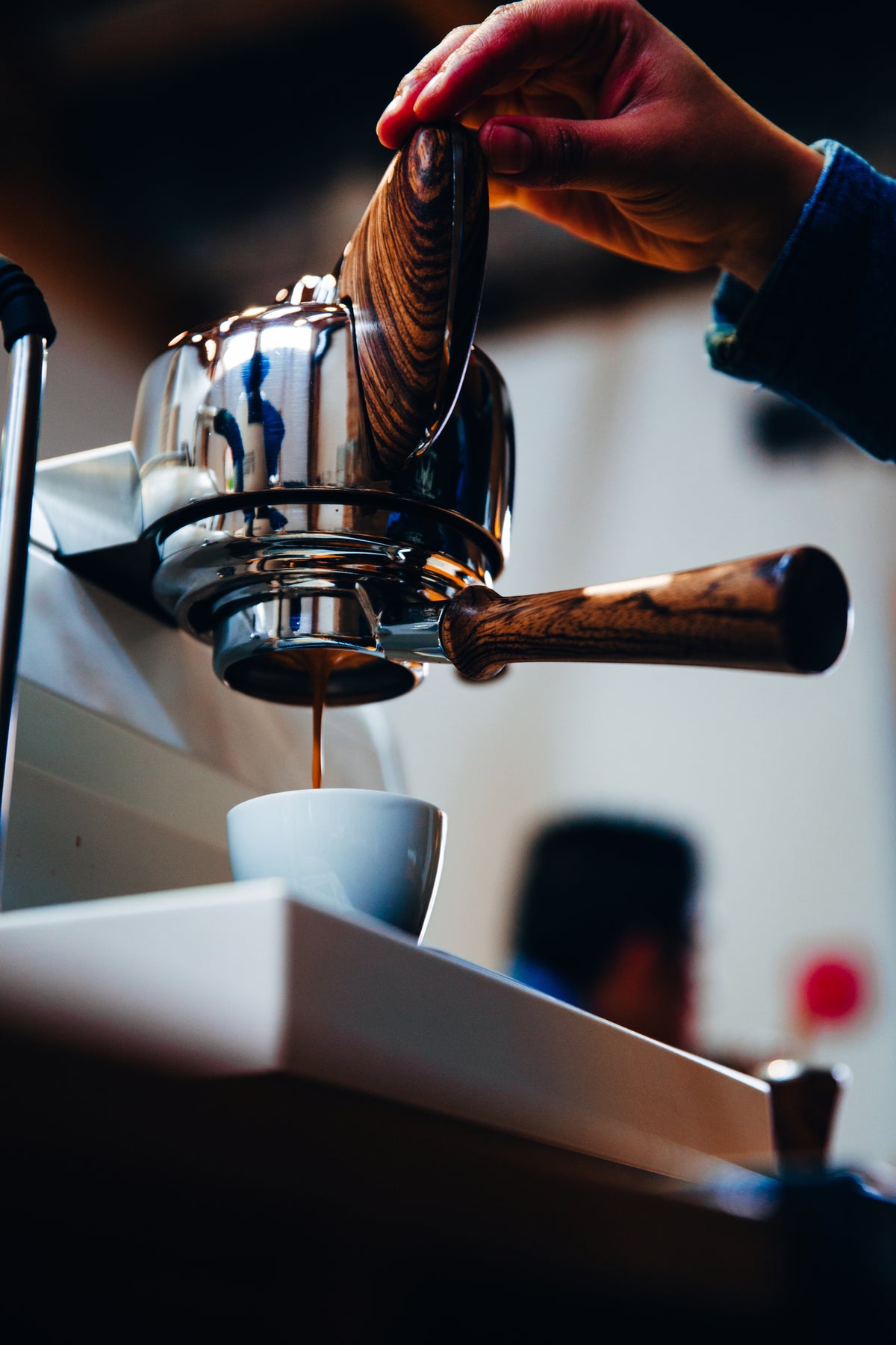 Premium espresso machine with dark wood handles in a modern coffee setting