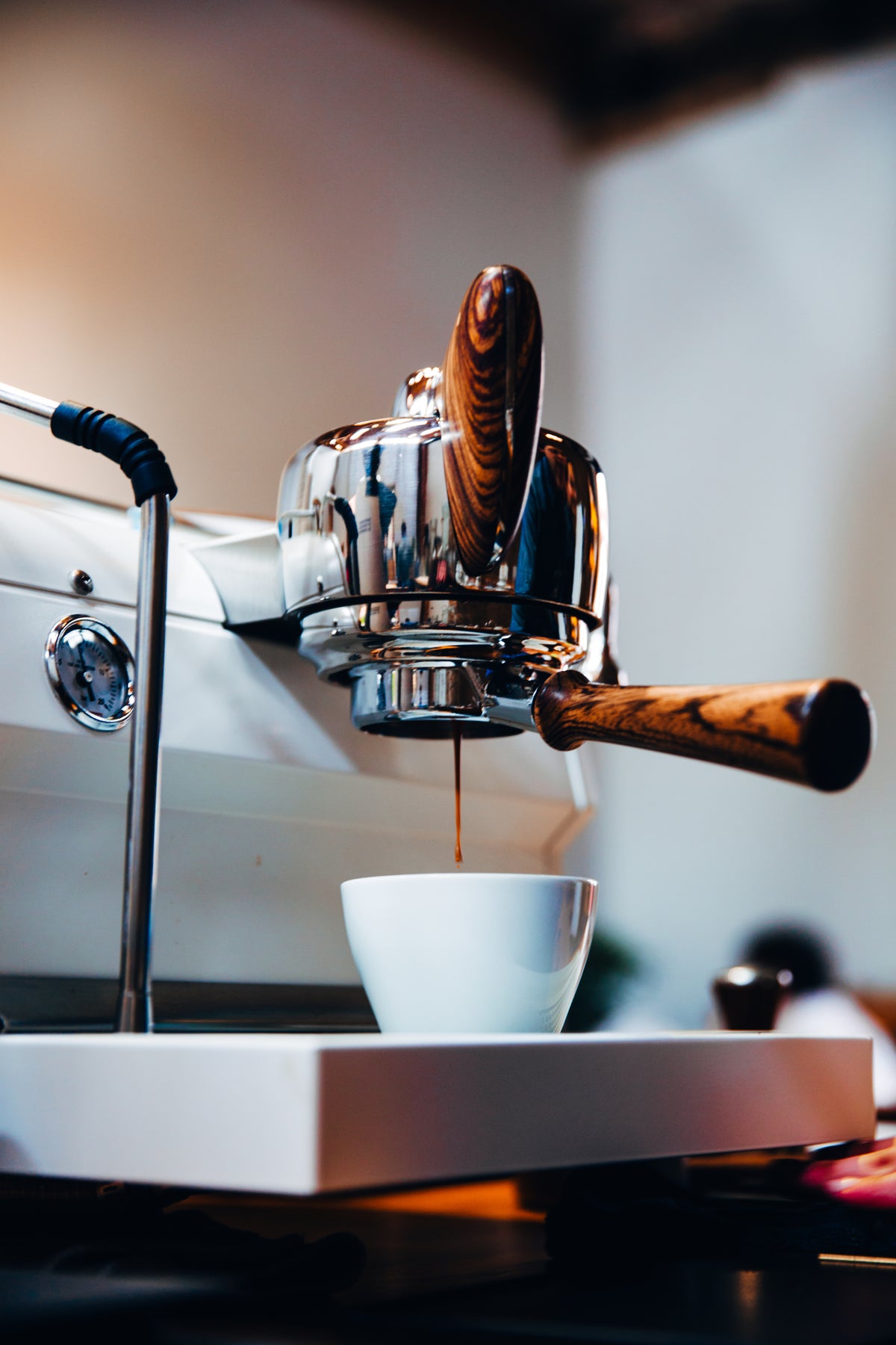 Espresso machine with wood handles preparing coffee in a modern setting